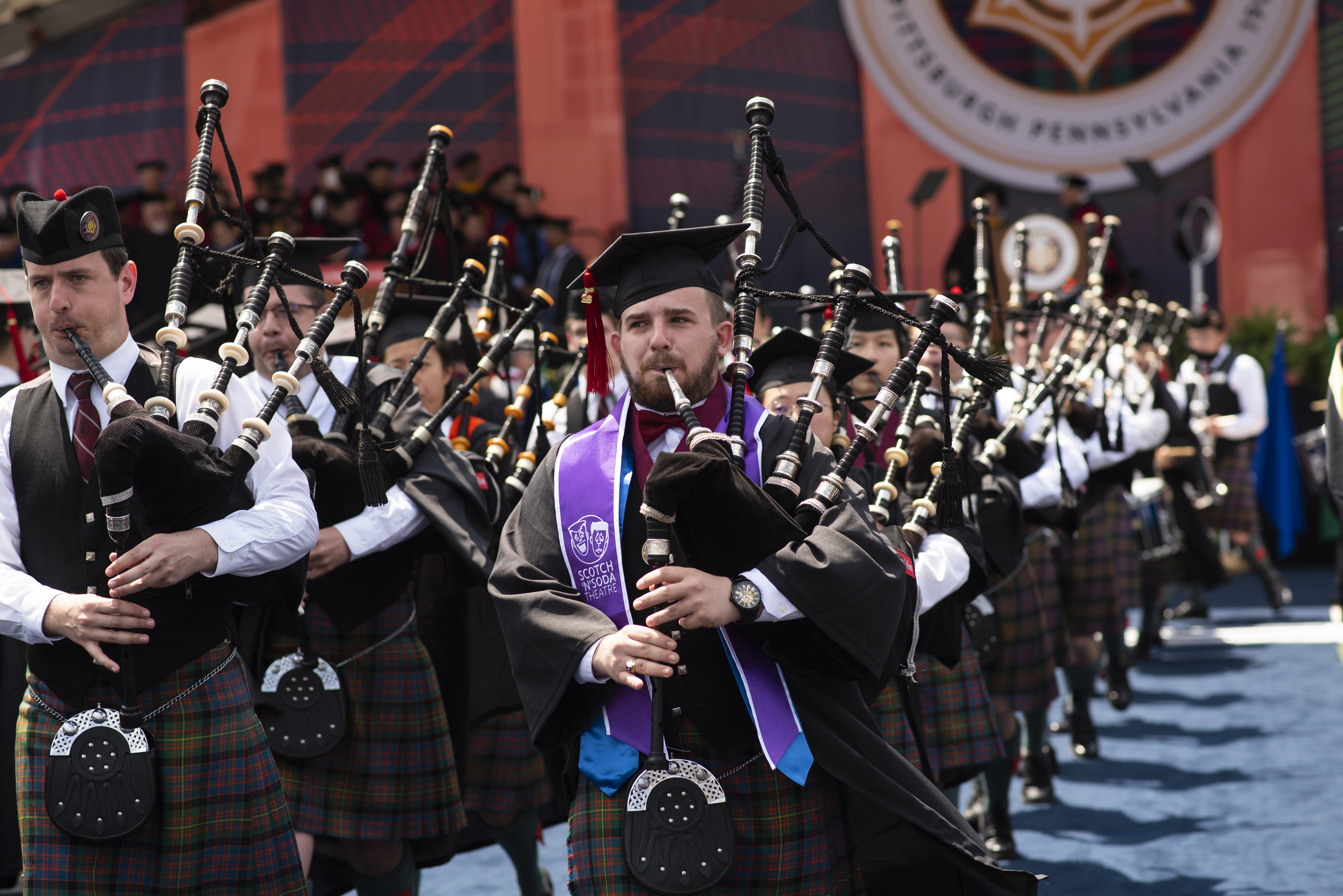 Members of the CMU Scotch n Soda Bagpipes group march at CMU commencement ceremonies