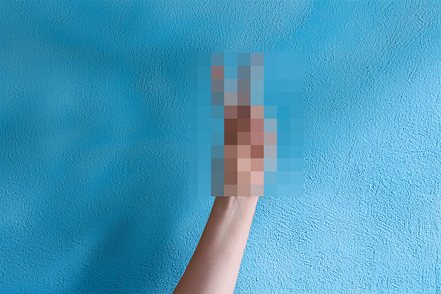 A human hand in front of a blue background, the gesture the hand is making is pixelated, as if censoring an offensive word or image