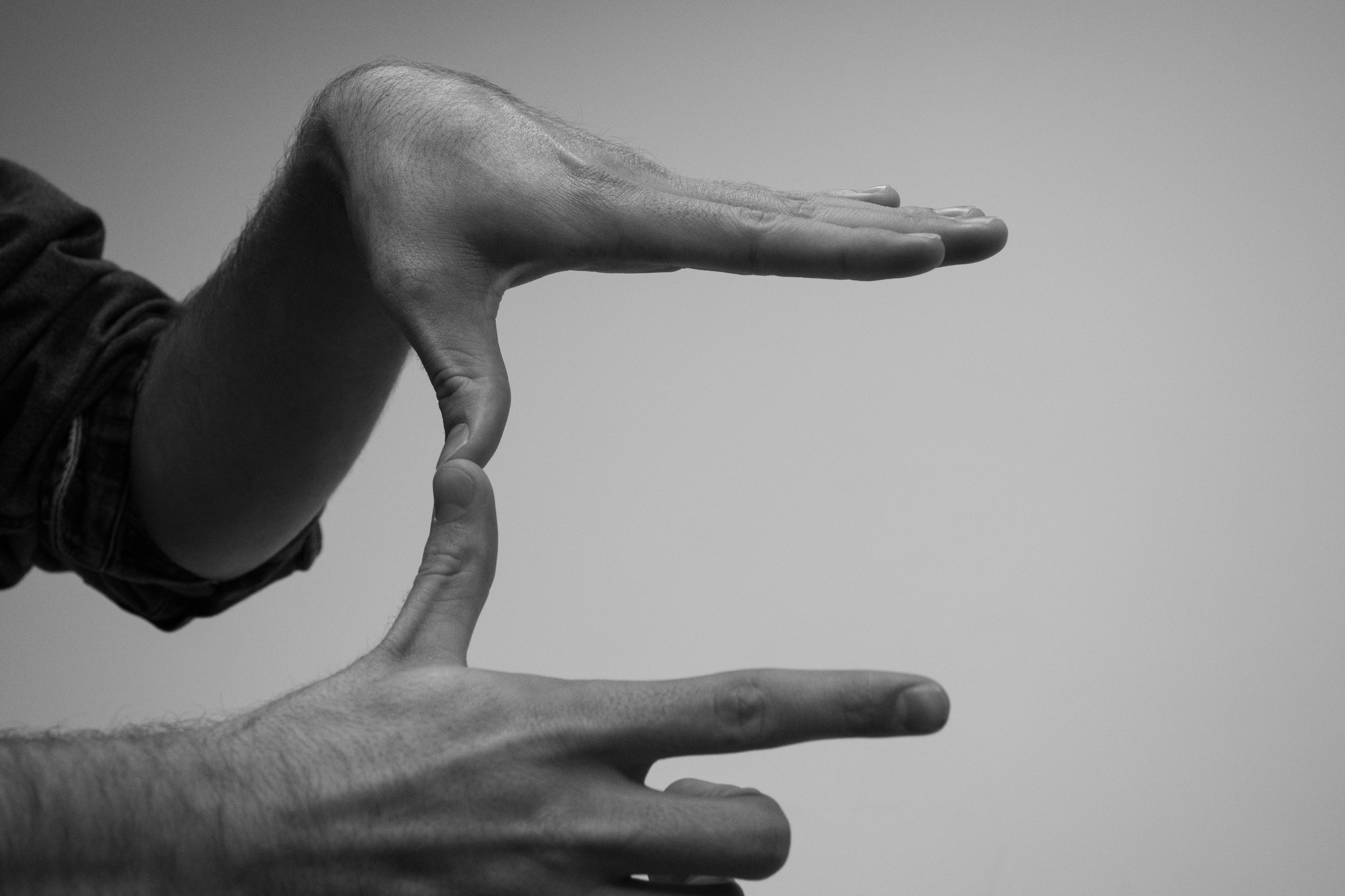 Stock photo in black and white of a pair of hands making a rectangular shape