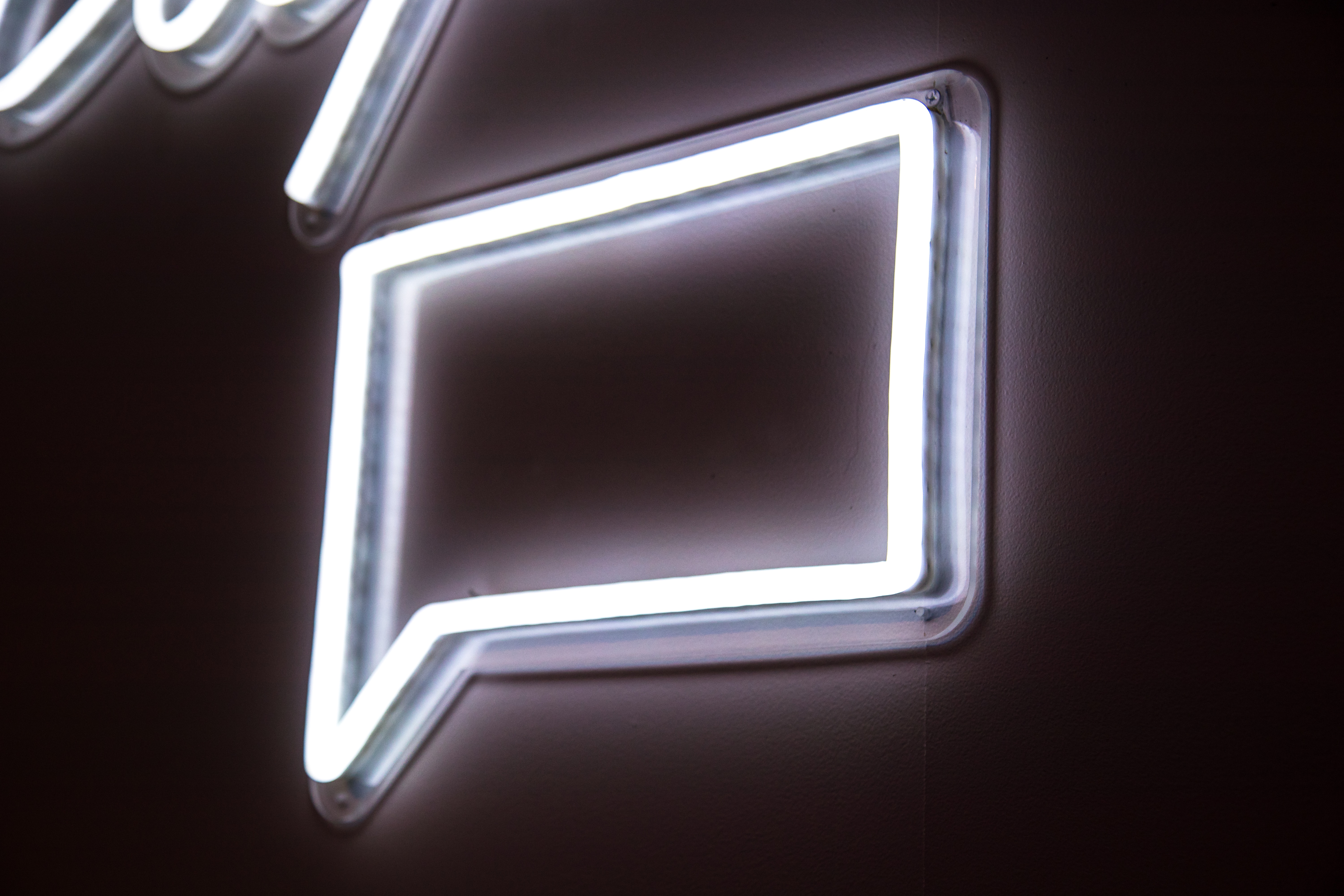 stock photo of a white neon sign in the shape of a speech bubble
