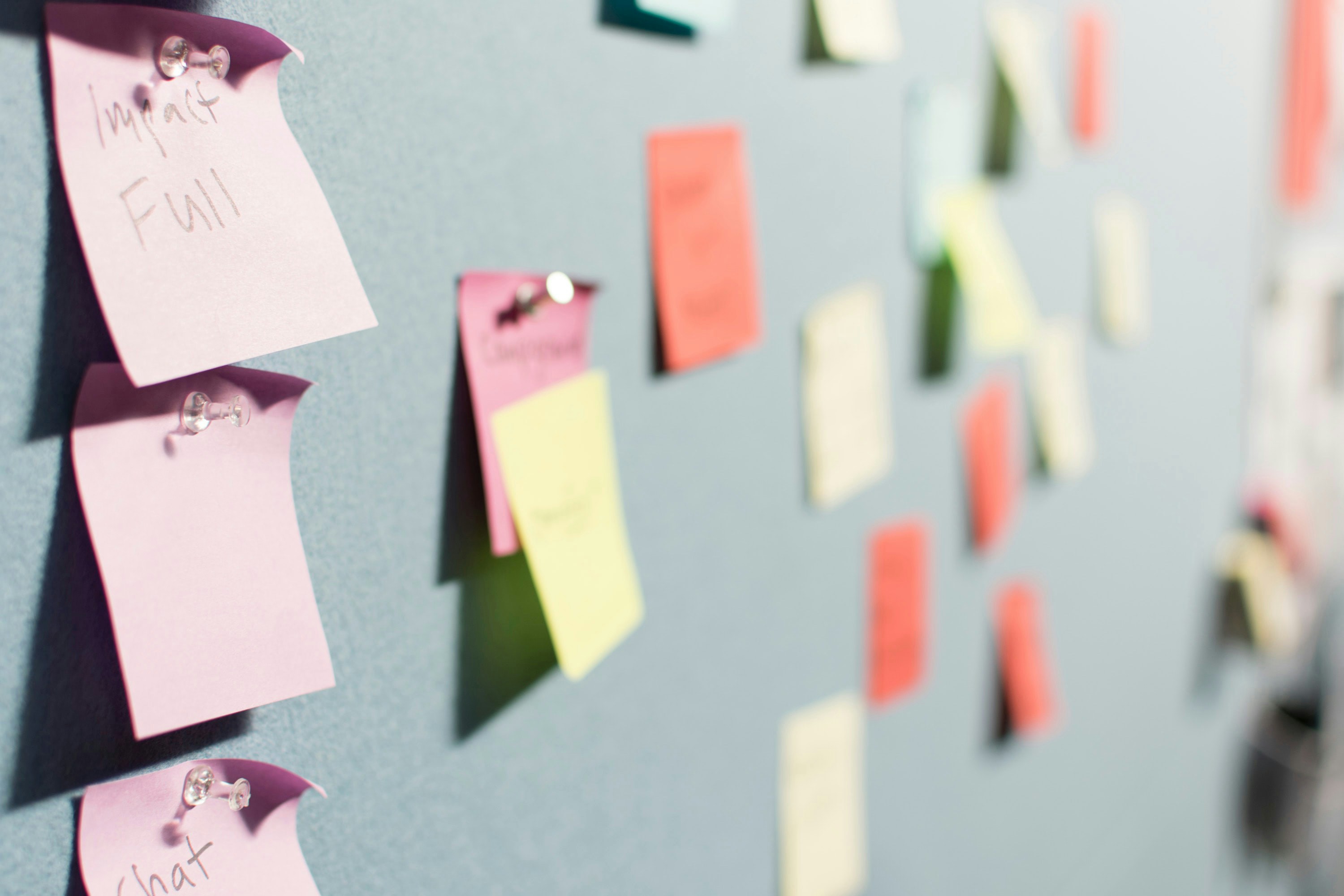 A wall covered in colorful post-it notes with writing on them