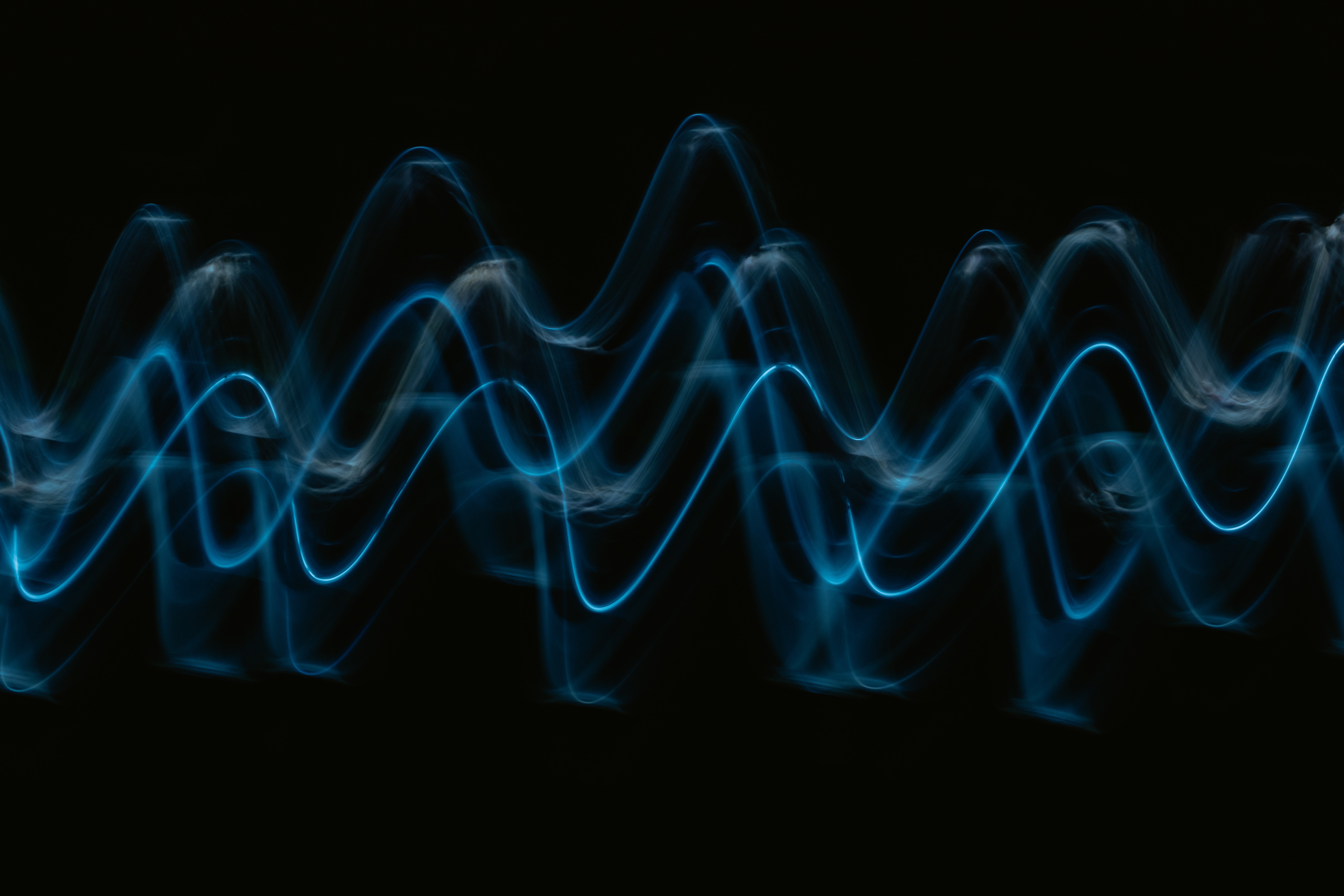 An abstract image of blue sine waves on a black background